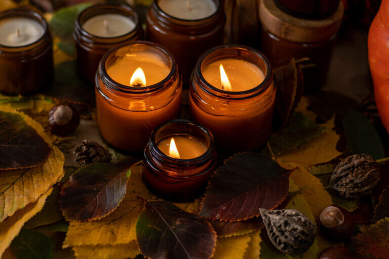 Scent of the Season: Autumn Leaves Soy candles burn in glass jars. Tree leaves. Comfort at home. Candle in a brown jar. Scent